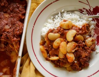 Western lima beans and rice in a small bowl next to the serving pan