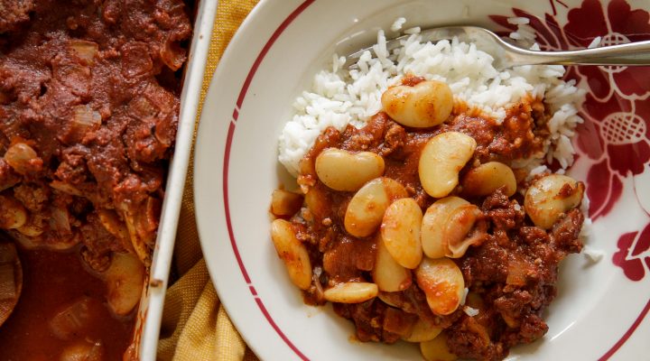 Western lima beans and rice in a small bowl next to the serving pan