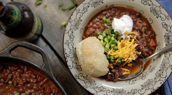 bowl of black bean chili with bread and toppings