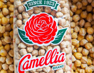 a close up of a bowwl full of camellia brand garbanzo beans with a package of camellia brand garbanzo beans on top of them