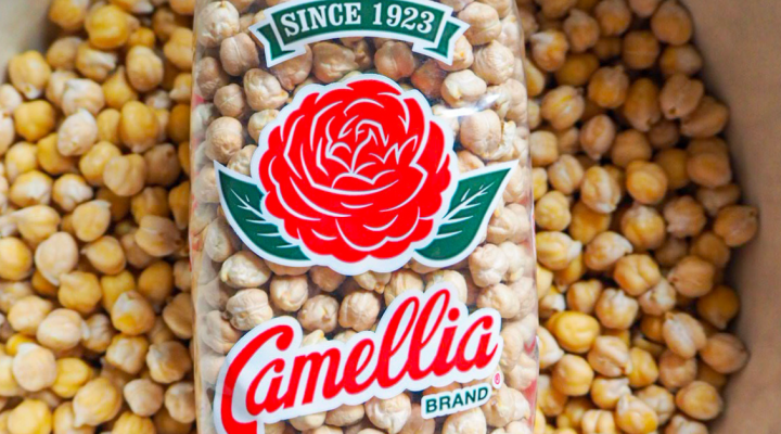 a close up of a bowwl full of camellia brand garbanzo beans with a package of camellia brand garbanzo beans on top of them