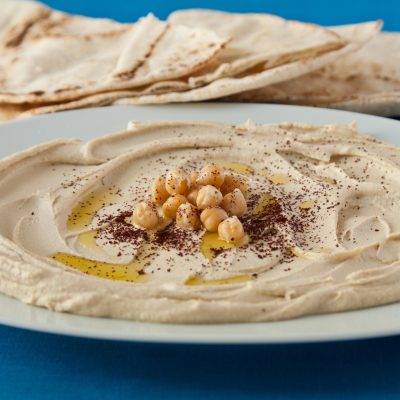 a bowl of Hummus next to some pita bread