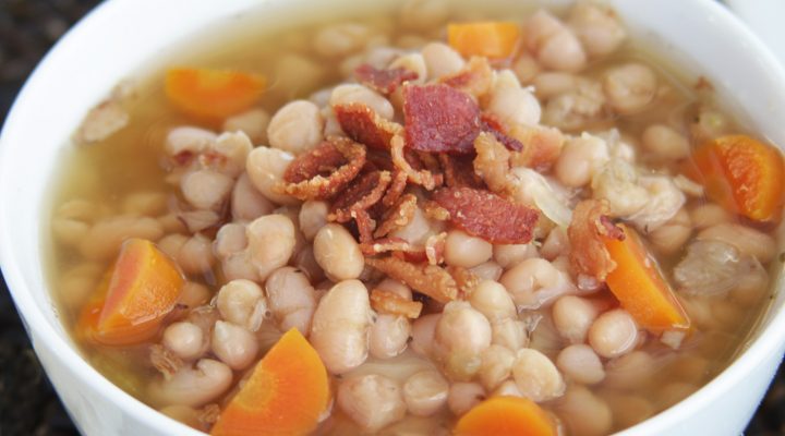 a close up of a bowl of navy bean bacon chowder