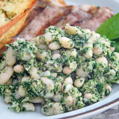 a close up of a plate of white bean spinach puree