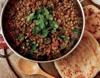 a pot of veggie lentils served with pita bread