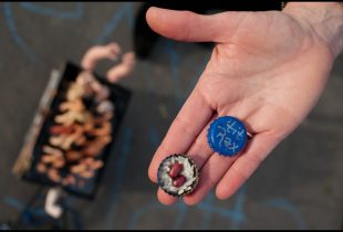 2 bottle caps decorated for the tit rex parade as throws