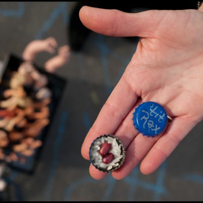 2 bottle caps decorated for the tit rex parade as throws