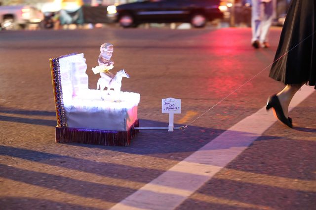 Traffic is stopped as a tiny float is pulled across St Claude Avenue