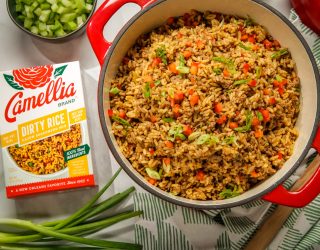 Gluten Free Cajun Dirty Rice in a red dutch oven next to a box of camellia brand dirty rice cajun seasoning mix