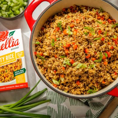 Gluten Free Cajun Dirty Rice in a red dutch oven next to a box of camellia brand dirty rice cajun seasoning mix