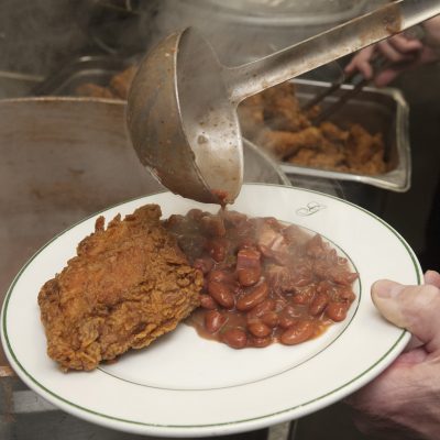a chef at Galatoires Red Beans Supper close up of fried chicken