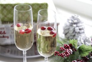 2 glasses of champagne with cranberries floating inside