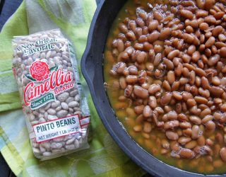 a dutch oven full of pinto beans next to a package of pinto beans