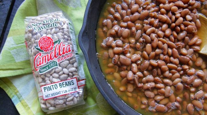 a dutch oven full of pinto beans next to a package of pinto beans