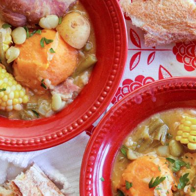 2 red bowls of caldo with camellia navy beans