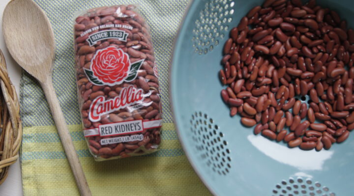 a close up of a package of red beans next to a strainer full of beans