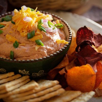 a close up of a plate of skinny red bean dip and a side of chips