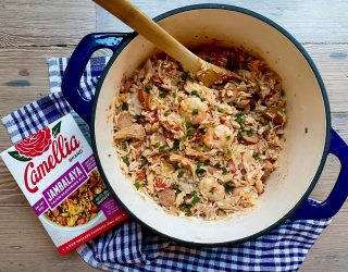 Blue dutch oven of Creole Jambalaya with Camellia Brand's Jambalaya Seasoning Mix next to it