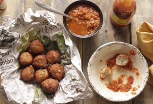 Blackeye Pea Fritters in a basket next to a bowl of salsa for diping