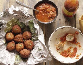 Blackeye Pea Fritters in a basket next to a bowl of salsa for diping