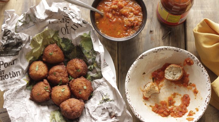 Blackeye Pea Fritters in a basket next to a bowl of salsa for diping