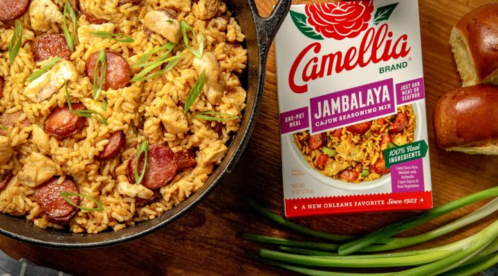Cajun Jambalaya in a dutch oven featuring sausage and chicken next to a box of camellia brand jambalaya cajun seasoning mix
