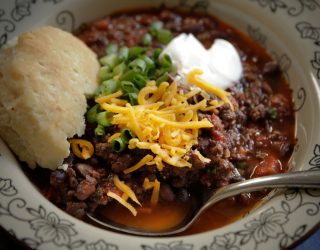 a plate of beef and black bean chili with a side of bread