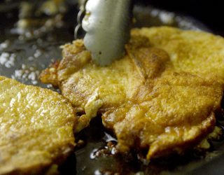 2 pork chops cooking in a skillet