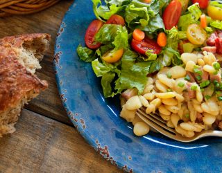 a plate of dorothy's delicious lima beans with a side salad and bread