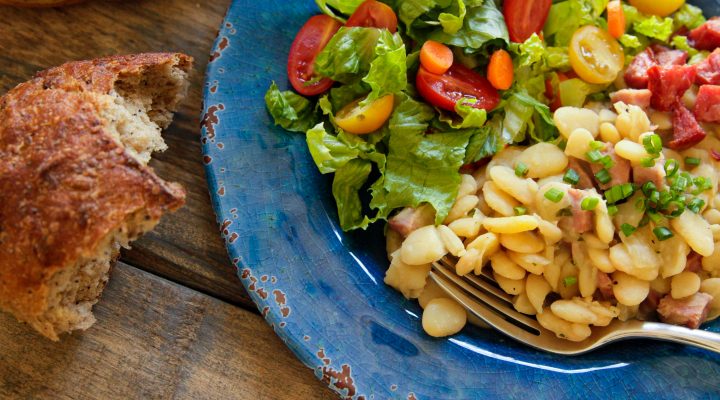 a plate of dorothy's delicious lima beans with a side salad and bread