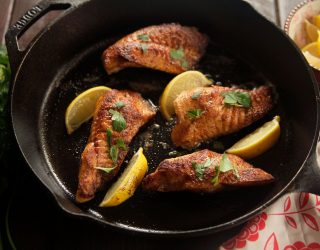 a cast iron pot with 4 pieces of golden sauteed catfish