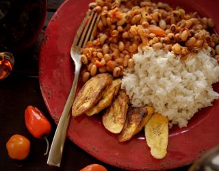 a plate of African red red with a side of rice and potato slices