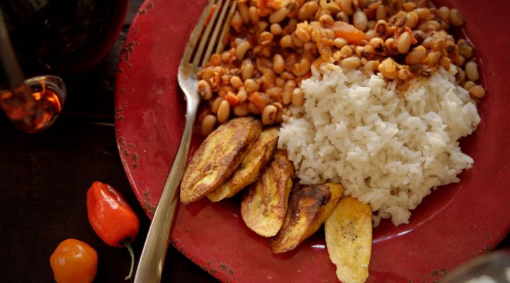 a plate of African red red with a side of rice and potato slices