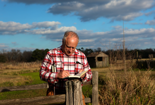 a farmer writing in his diary outside