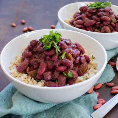 a close up of 2 bowls of red beans and rice