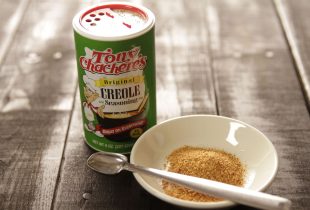 a close up of a dish full of tony's creole seasoning next to the container it came from