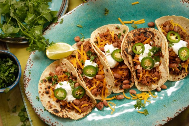 a plate full of 4 shredded pork pinto tacos