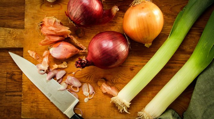 a cut board with a variety of onions