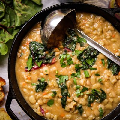 a dutch oven full of beans and greens soup