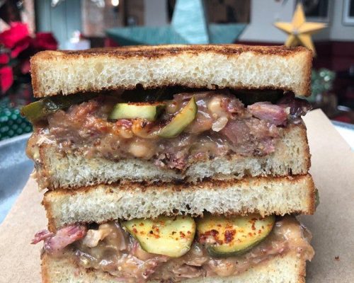 a close up of the inside of a white bean and smoked pork sandwich on texas toast