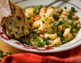 a close up of a plate of cafe reconcile white beans and shrimp