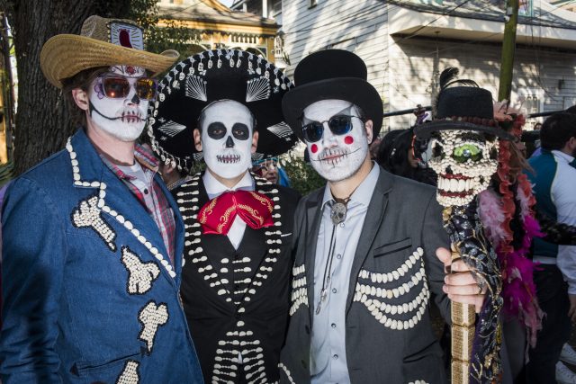 3 people wearing outfits adorned with beans for the dead bean parade