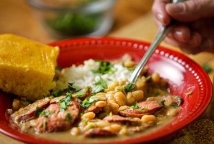 a close up of a plate of south louisiana style white beans and rice and a side of corn bread