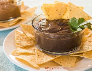 a dipping cup of canal bistro chipotle bean dip with chips