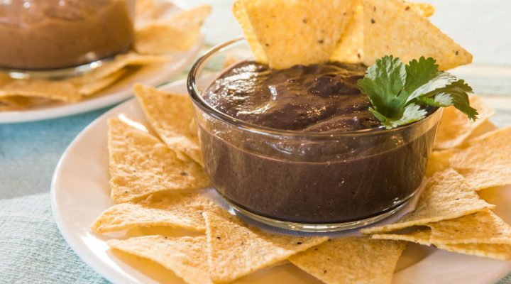 a dipping cup of canal bistro chipotle bean dip with chips