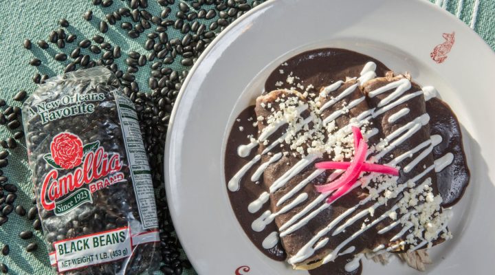 a plate of canal bistro enfrijoladas next to a package of black beans