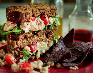 white bean tuna sandwich with tomatoes on a plate with chips