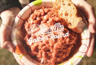 two hands holding a bowl of red beans and rice