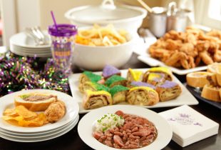 red beans and rice with a side of mashed potatos at a mardi gras party with king cake and bbq chips