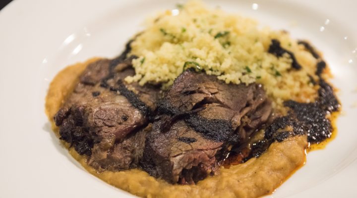 a plate of braised short rib and berbere split peas